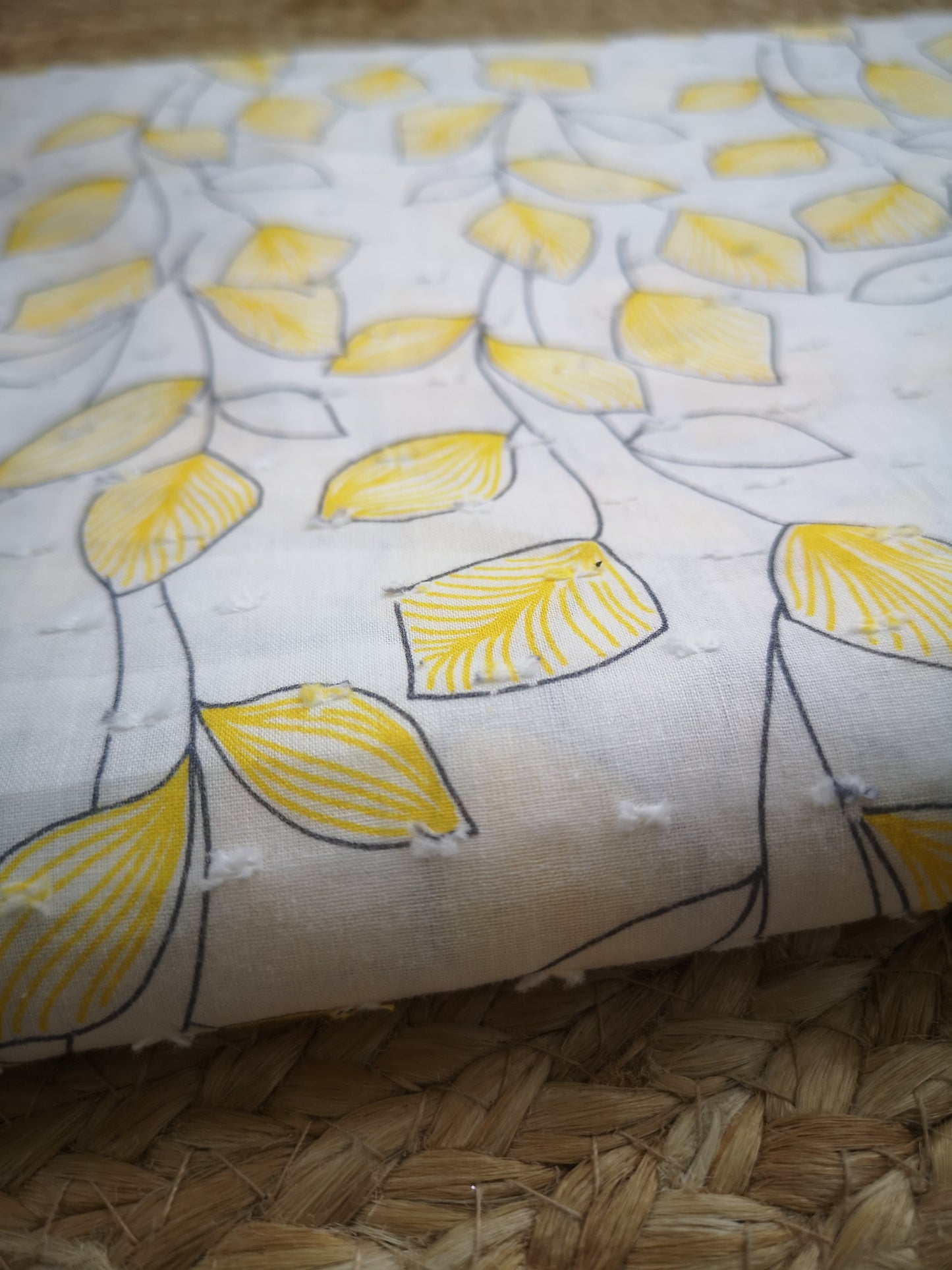 Voile de coton plumetis motif feuilles jaunes (prix par 50cm)