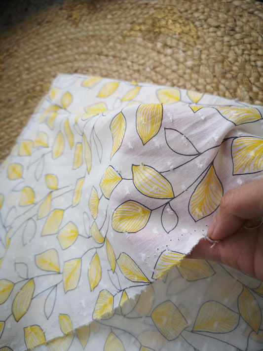 Voile de coton plumetis motif feuilles jaunes (prix par 50cm)