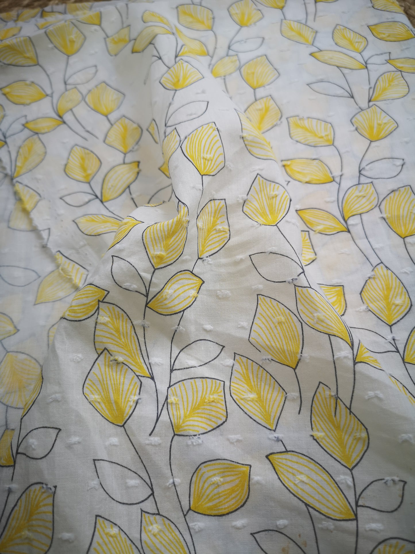 Voile de coton plumetis motif feuilles jaunes (prix par 50cm)